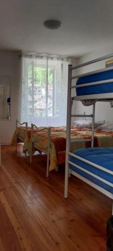 a bedroom with two bunk beds and a wooden floor at B&B Arquino in Sondrio