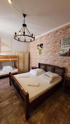 Cama grande en habitación con pared de ladrillo en Hostel Chmielna 5 Rooms & Apartments, en Varsovia