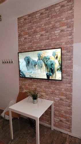 una TV a schermo piatto montata su un muro di mattoni di Hostel Chmielna 5 Rooms & Apartments a Varsavia