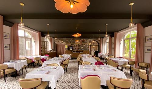 une salle à manger avec des tables et des chaises blanches dans l'établissement Park Hotel Bellevue, à Trégastel