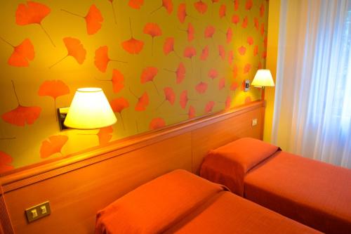 a hotel room with two beds and a lamp at eco Hotel Milano & BioRiso Restaurant in Milan