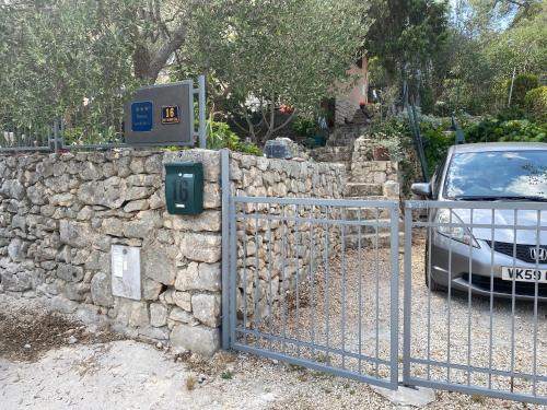 un coche aparcado junto a una pared de piedra con una puerta en Apartman Silna your new home with terrace and garden en Bobovišća