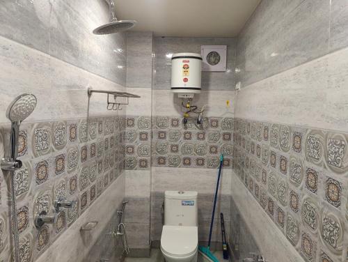 a bathroom with a toilet in a room with tiles at Alpine Valley Homestay in Shimla
