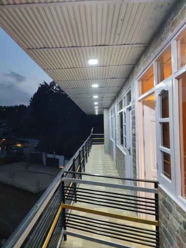 a balcony of a building with a staircase leading to a window at Alpine Valley Homestay in Shimla