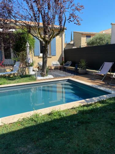 una piscina en un patio con un árbol en Gîte Lou Sabaï au pied des dentelles de Montmirail, piscine partagée, en Aubignan