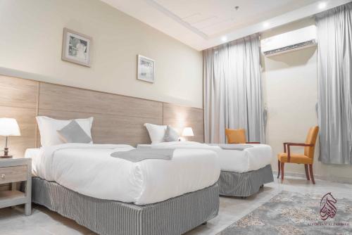 una camera d'albergo con 2 letti e una scrivania di فندق صحارى الفرسان a Şabyā