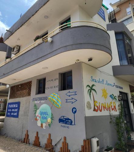 a building with a sign on the side of it at Seashell Beach Rooms in Durrës