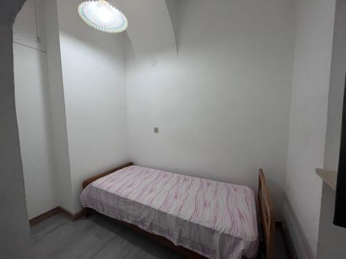 ein kleines Schlafzimmer mit einem Bett und einer Lampe in der Unterkunft Casa vacanze la volta in Rodi Garganico