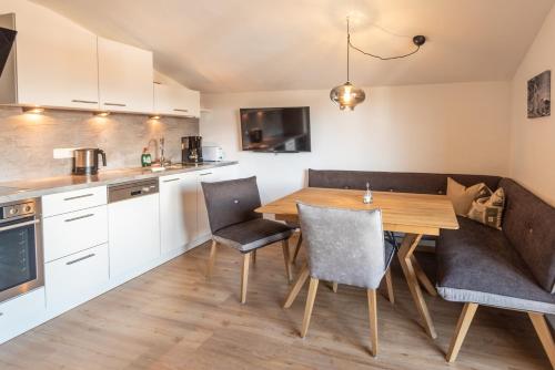cocina y comedor con mesa de madera y sillas en Apartments Foidl en Kitzbühel