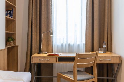 a desk with a chair in front of a window at RAJ zdravia in Bratislava