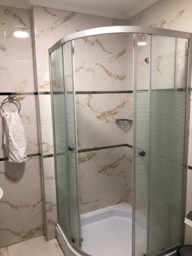 a shower with a glass door in a bathroom at Hilal House in Degirmen