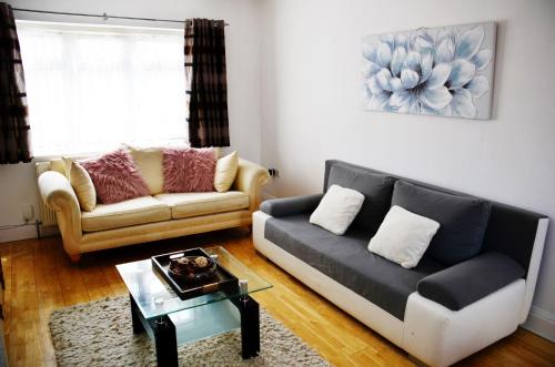 a living room with a couch and a coffee table at 29EW Dreams Unlimited Serviced Accommodation- Staines - Heathrow in Stanwell