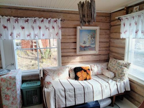 uma sala de estar com um sofá e uma janela em Mummola em Taluskylä