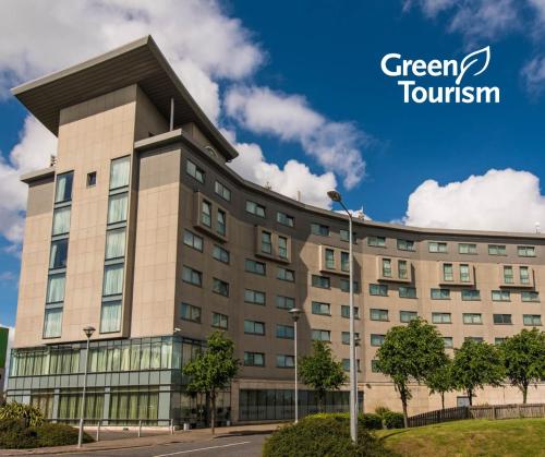 a building with the green township logo on it at Aspect Hotel Park West in Clondalkin 