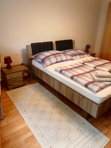 a bedroom with a bed and a rug on the floor at Új Lilla Apartman in Keszthely