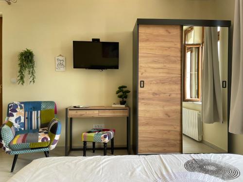 1 dormitorio con 1 cama, 1 silla y TV en Apartments Villa Dinka, en Hvar