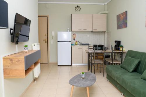 ein Wohnzimmer mit einem grünen Sofa und einer Küche in der Unterkunft Sunshine Apartments #01 in Thessaloniki