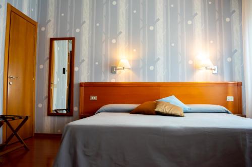 a bedroom with a large bed and a mirror at eco Hotel Milano & BioRiso Restaurant in Milan