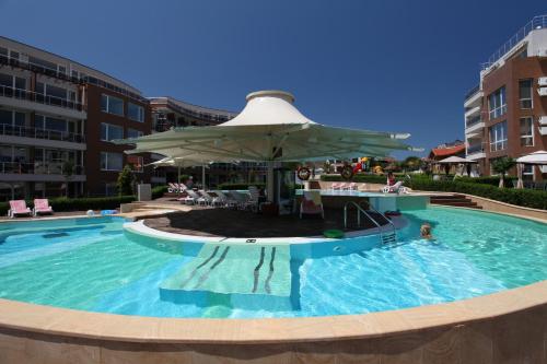 a large swimming pool with an umbrella in a building at Апартамент Sunny home in Chernomorets