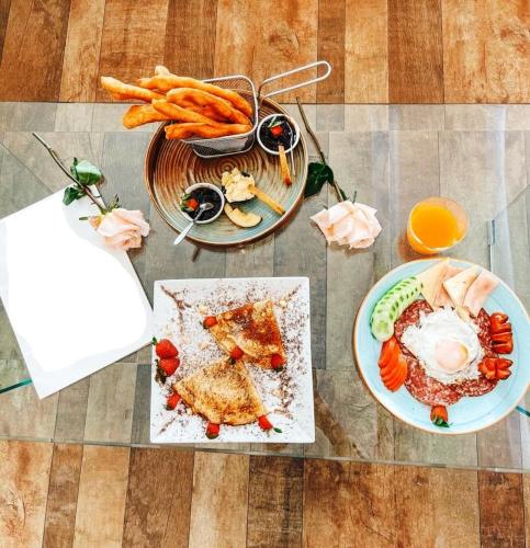 a table with two plates of food and carrots at Seashell Beach Rooms in Durrës
