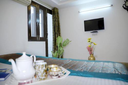 新德里的住宿－DIVINE INDIA SERVICE APARTMENT 3BHK, J-215 SAKET，一间设有花瓶桌子和蜡烛托盘的客房