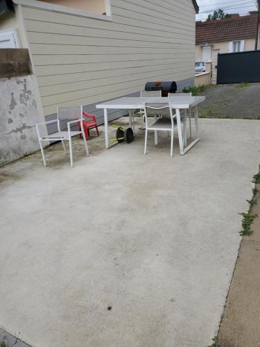 une table de pique-nique et deux chaises dans une allée dans l'établissement proche circuit 24h du mans Maison 3 chambres, au Mans