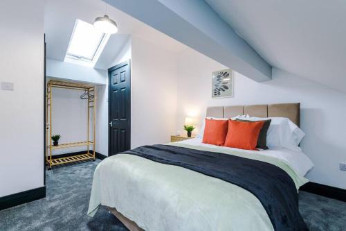 1 dormitorio con 1 cama grande con almohadas de color naranja en Mansa Musa House - 5 Bed 5 En Suite Bathrooms, Newly Refurbished House with free parking outside en Liverpool