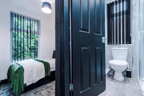 1 dormitorio con 1 cama, aseo y puerta en Mansa Musa House - 5 Bed 5 En Suite Bathrooms, Newly Refurbished House with free parking outside en Liverpool