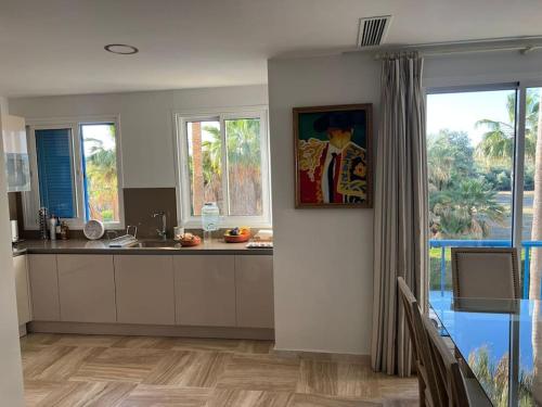 a kitchen with a sink and a counter with windows at Sotogrande Marina Beach in Sotogrande