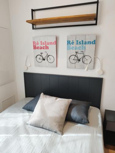 - une chambre avec des affiches sur le mur et un lit dans l'établissement Le St Louis 1 Chambre aménagée avec cuisine, à La Rochelle