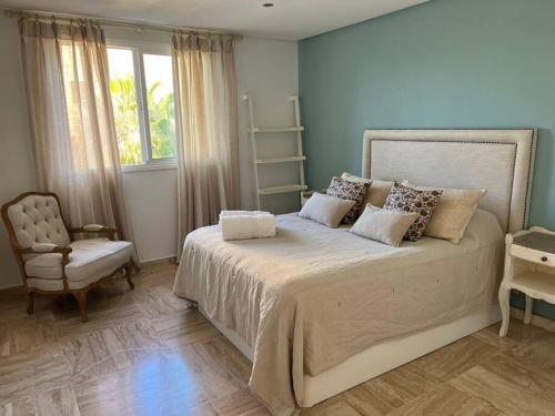 1 dormitorio con 1 cama con silla y ventana en Sotogrande Marina Beach, en Sotogrande