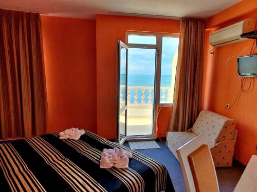 ein Hotelzimmer mit einem Bett und einem Fenster in der Unterkunft Family Hotel Paros in Pomorie