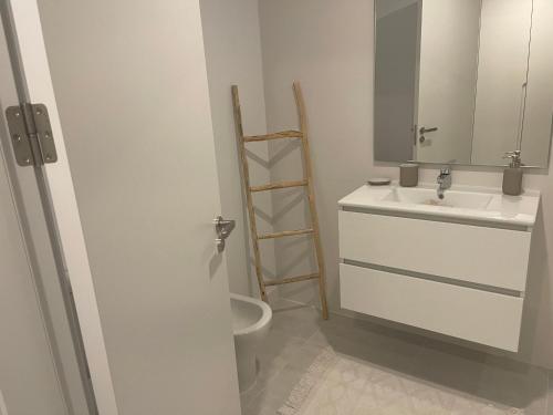 a bathroom with a sink and a toilet and a mirror at Vanian Gardens Apartment -Stella in Estepona