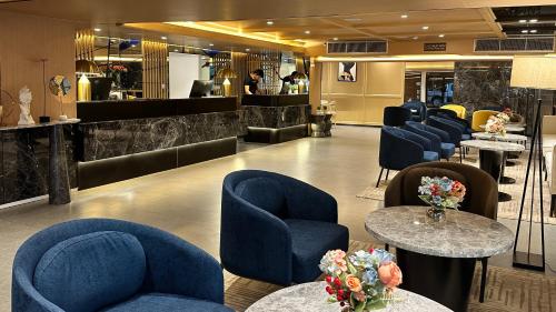 a waiting room with blue chairs and tables at Ramada Sukhumvit Soi Eleven in Bangkok