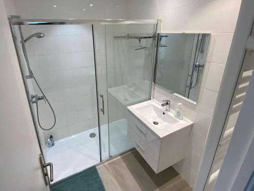 uma casa de banho branca com um chuveiro e um lavatório. em Appartement Le Lavandou, 2 pièces, 4 personnes - FR-1-308-175 em Le Lavandou