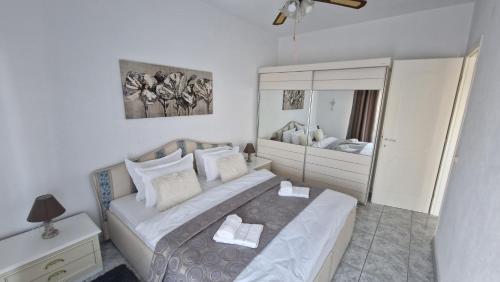 a bedroom with a large bed and a mirror at Doukas Aparthotel in Ofrínion