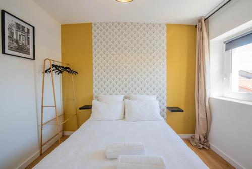 sypialnia z białym łóżkiem i żółtą ścianą w obiekcie WelcomeAgen - Al Capone - Clim - Wifi Fibre - Cosy w mieście Agen