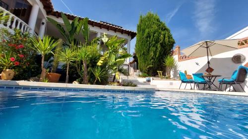 Mondrón的住宿－Villa Mondriana，房屋旁的游泳池配有椅子和桌子