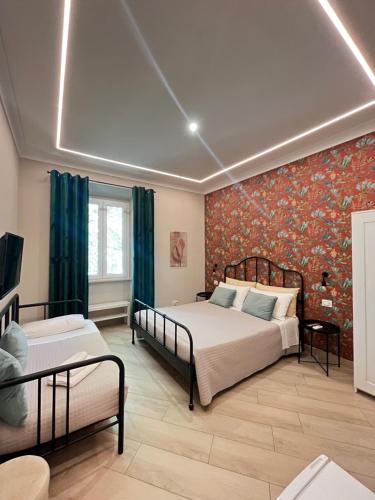 una camera con due letti e una parete floreale di B&B Vittoria ad Anzio