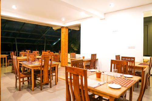 an empty restaurant with wooden tables and chairs at 3 Arch Resort Ella in Ella