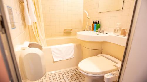 ein kleines Bad mit WC und Waschbecken in der Unterkunft 小牧シティホテル in Komaki