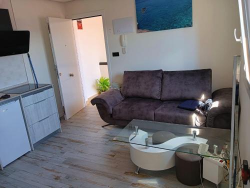 uma sala de estar com um sofá e uma mesa de vidro em Apartamento en primera línea de mar, las Teresitas, Santa Cruz de Tenerife em San Andrés