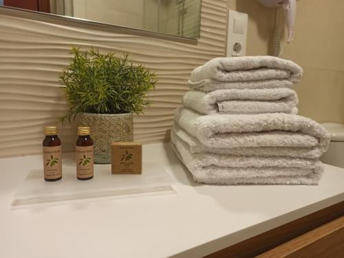 un montón de toallas sentadas en un mostrador en un baño en A casa do campo en Zas