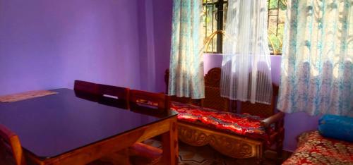 a purple room with a table and a window at Blessing Homestay Ahaldara in Mangpu