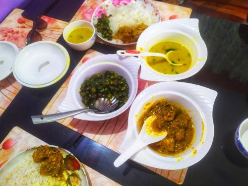 a table topped with bowls of food and bowls of rice at Blessing Homestay Ahaldara in Mangpu