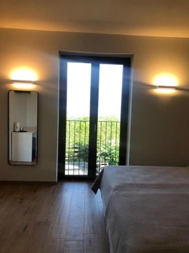 a bedroom with a bed and a mirror and a window at Agriturismo Forest B&B in Iseo
