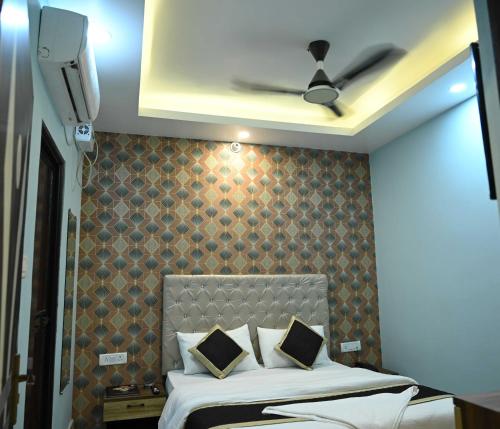 a bedroom with a bed with a brown wall at Hotel O Glance Inn in Patna