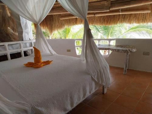 Un dormitorio con una cama blanca con una red en AL FARO Cosmio Hotel Palawan, en Busuanga