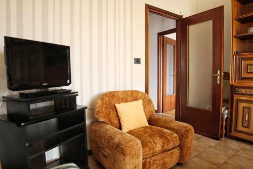 een woonkamer met een stoel en een televisie bij RITA & GIO in Cuneo