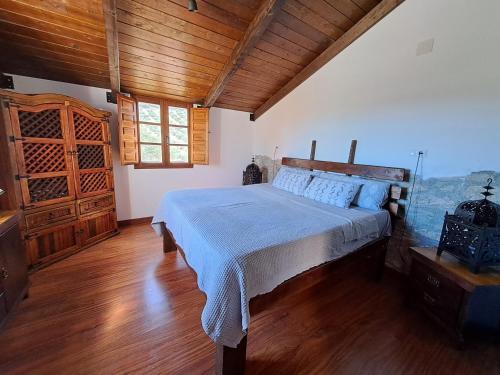 1 dormitorio con cama y techo de madera en Cortijo Berruguilla, en Lojilla